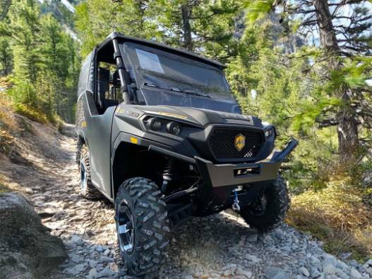 dynamic powersports quad, determined, climbing a steep hill, photorealistic, rocky mountain path, highly detailed, loose gravel flying, 4K output, cool blues and grays, early morning light, shot with a telephoto lens